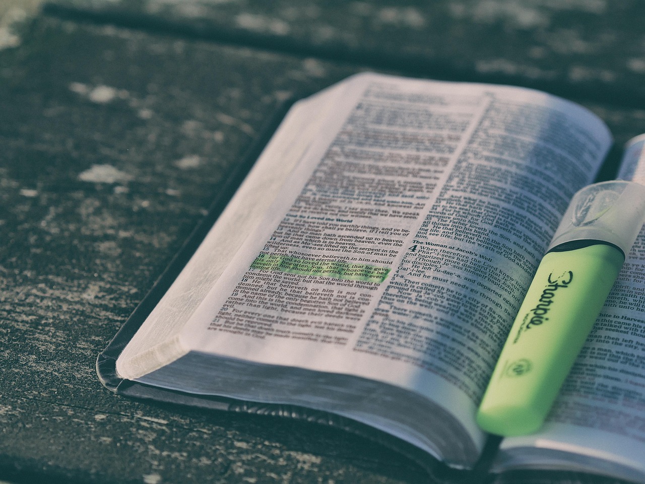 An open Bible on a wooden table next to a cup of tea, symbolizing peace and healing meditation.